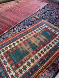 Worn antique Caucasian rug with distressed pile and authentic mountain tribe character.