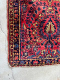 Antique red floral Persian rug woven in the 1920s with a dark navy border