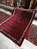 Small decorative Persian rug showcasing paisley and floral designs.