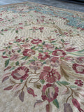 Antique French tapestry rug with delicate floral artwork in sage green, ivory, and dusty rose.
