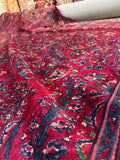 Deep jewel-toned Persian rug shown in natural light.