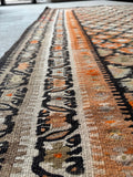 Antique flat weave with Rorschach-style floral chain border.