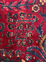Close-up of floral motifs on ruby-toned Lilihan rug.