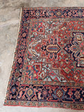 Rust and ice blue Persian area rug styled in daylight revealing rich color variation and matte wool finish.