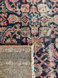 Underside view of antique navy Persian runner with water garden pattern and low pile.