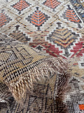 Antique geometric rug displaying tree of life patterns on a warm wheat background