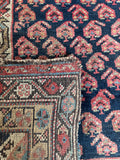 Rustic midnight blue and rust Persian runner crafted by Kurdish tribal weavers.