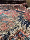 5x6 antique Persian rug detail with geometric medallion motifs and softened vegetable dyed palette.