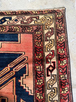 Handwoven floral border pattern on antique Persian rug.