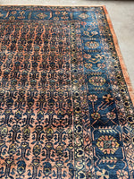Coral-ground rug with yellow, turquoise, and soft green paisley motifs in near mint condition