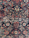 Close up of Persian Ferahan rug. Hand knotted antique gallery rug with dense Herati motifs, ivory corner spandrels, and a beautifully mellowed palette. Some minor repairs to ensure longevity.