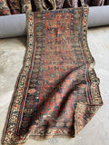 Antique Persian scatter rug with authentic wear, tribal floral pattern and old-world handmade charm.