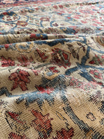 Folded view of the rug emphasizing texture and softness of the worn wool.