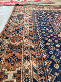 Close-up of antique Persian Shiraz rug border bands with tribal motifs.
