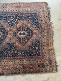 One end of vintage Persian Shiraz rug showing overall pattern with balanced tribal composition.