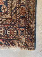 Corner view of well-worn Shiraz rug crafted from 100% raw wool foundation and pile.