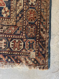 Corner view of well-worn Shiraz rug crafted from 100% raw wool foundation and pile.