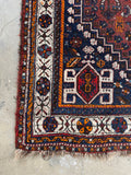 Corner view of border detail showing pinwheel of life motif on ivory ground.
