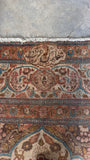 Woven inscription at the top of a signed antique Persian Tabriz rug in the 9x12 size range.