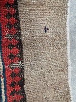 Small signature-like mark woven into the Seraband runner.