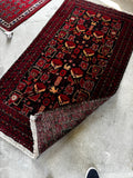 Small vibrant Persian rug 3x6 black and red with bold tribal animal motifs, full pile wool