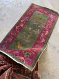 Antique 1930s Art Deco rug with a mossy green field and fuchsia floral border.