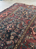 Low pile antique Persian rug with naturally aged wear and soft earthy tones.