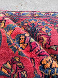 Small antique wool table rug with floral border in aqua blue and berry pink.