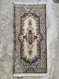 2x4 vintage Persian Kerman rug with an ivory field, blue border and floral design.