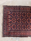 Rustic boho Baluch small rug placed flat, ideal for adding warm texture to an entryway, hallway, or reading nook.