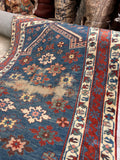 Antique blue prayer rug with a lattice-like design of blossoms and simple floral chain borders.