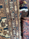 Vegetable dyed wool tribal rug side-by-side shot among a collection of vintage handmade Persian rugs.