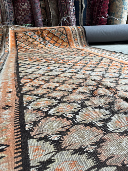 Antique runner in mellowed dyes with pops of tangerine.