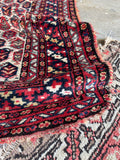 1920s Persian area rug showing scattered time-earned wear and vibrant natural dyes.