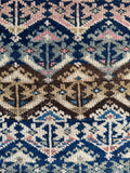 Close up of antique Persian rug runner with navy blue field transitioning into deep coffee tones.