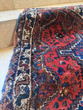Vegetable-dyed wool Persian rug showing rich tribal geometric patterns and soft texture.