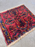 Antique Persian Bibikabad rug mat in red and turmeric yellow with central floral design.