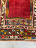 Hand knotted prayer rug detail highlighting turmeric yellow and ivory star patterns.