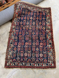 Navy Persian Kurdish scatter rug with tribal birds and flowering plants.
