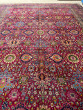 Magenta-ground Persian rug with stylized blossoms and vines