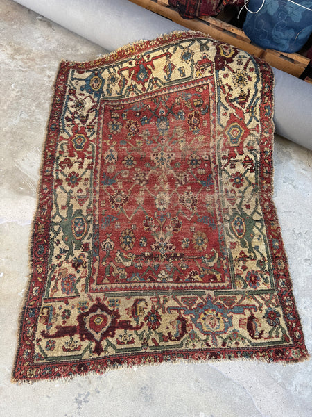 Antique 19th century Persian Sultanabad Mahal rug with worn brick red field and oatmeal border.
