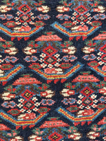 Detailed view of outlined paisley designs on a handwoven Kurdish rug.