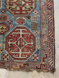 Graphic Caucasian rug border with alternating colors and angular tribal patterns.