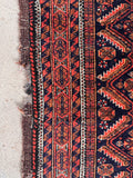 Deep blue red entryway rug side view showing fine hand-spun wool knots and natural aging characteristics and some wool loss.