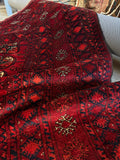 Detailed border bands on a Afghani rug with tribal motifs.