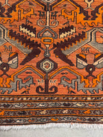 Tribal animal motifs across the main field of the rug.