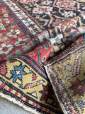 Folded view of an antique Caucasian rug from the turn of the century.