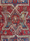 Close up of authentic late 19th century prayer rug with vegetable dyed wool and tribal symbolism.