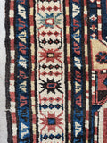 Handwoven Kazak area rug with geometric medallions and natural wool dyes.