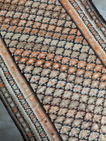 Featherweight flat weave runner with playful tangerine highlights.